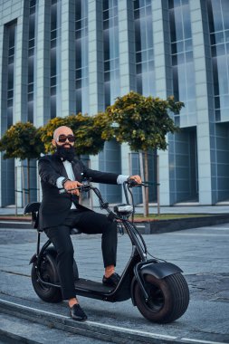 Adam yeni elektrikli bisikletine biniyor.