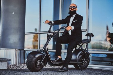 Adam yeni elektrikli bisikletine biniyor.