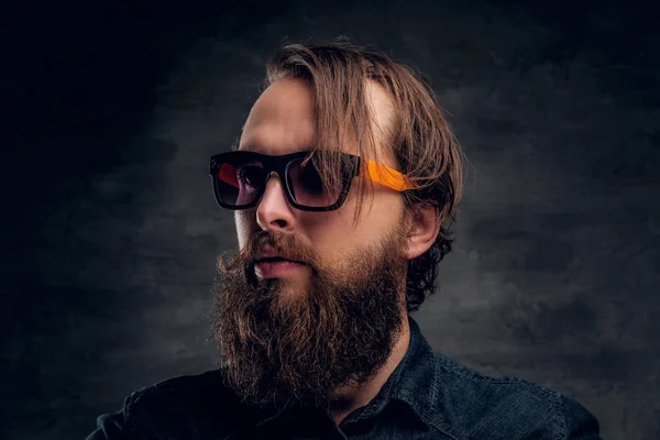 Attractive bearded man in sunglasses over dark background. — Stock Photo, Image