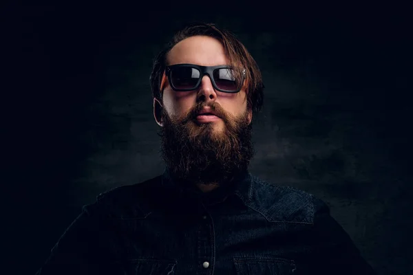Attractive bearded man in sunglasses over dark background. — Stock Photo, Image
