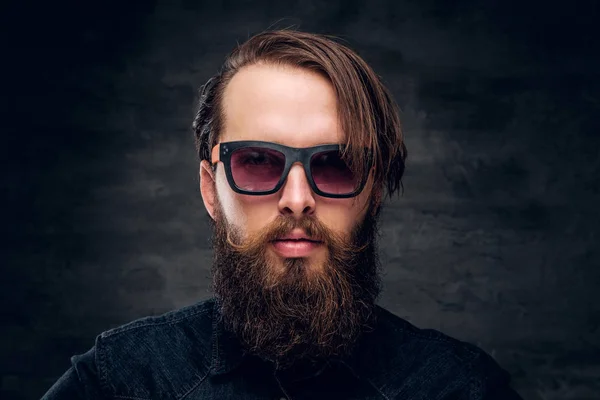 Homem barbudo atraente em óculos de sol sobre fundo escuro . — Fotografia de Stock