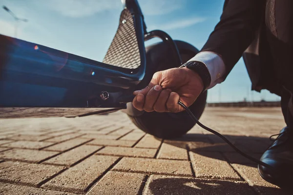 L'homme charge son nouveau scooter électrique — Photo