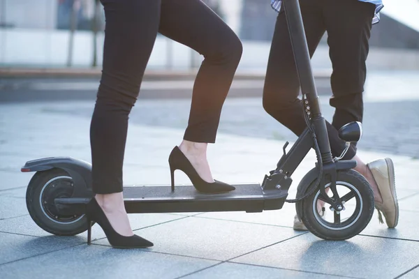 Legs of two females with electrical scooter — Stock Photo, Image