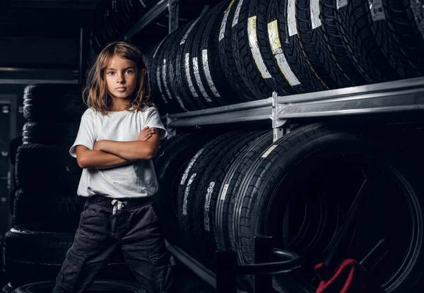 一个女孩在黑暗的轮胎存储的肖像 — 图库照片