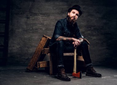 Şapkalı vahşi adam balta tutuyor