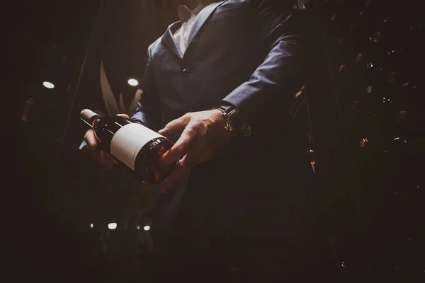Eleganter Mann im Anzug im Weinkeller mit Flasche Wein — Stockfoto