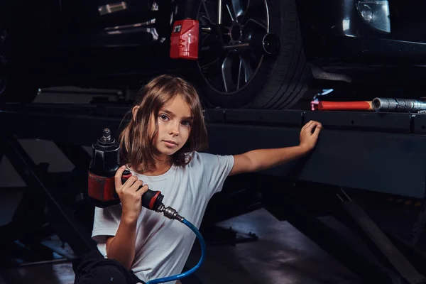 Portrait of little kid at dark auto service — Stock Photo, Image