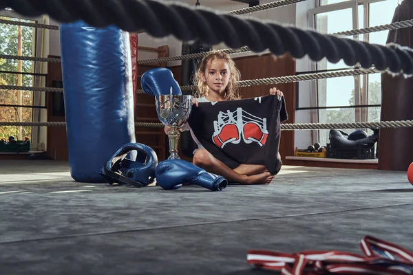 Little girl is chilling after competition at boxing ring