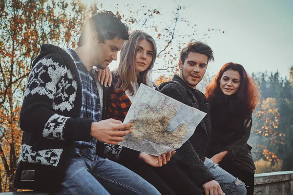 Los jóvenes están buscando el camino correcto usando el mapa — Foto de Stock