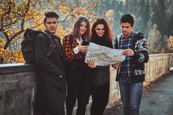 Jongeren zijn op zoek naar het juiste pad met behulp van kaart — Stockfoto