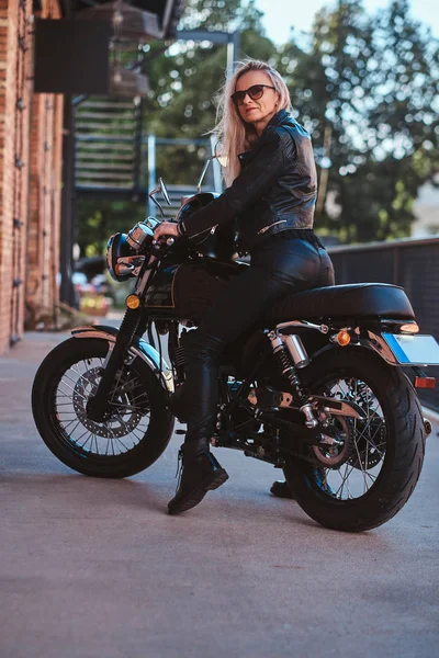 Retrato de sexy matyre motorista femenina junto al edificio de ladrillo — Foto de Stock