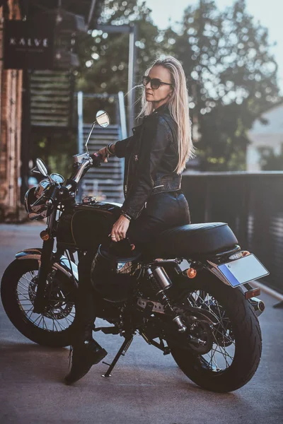 Retrato de sexy matyre feminino motociclista ao lado de tijolo edifício — Fotografia de Stock