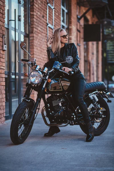 Bonito motociclista feminino está posando para fotógrafo com sua moto — Fotografia de Stock