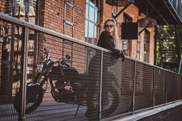 Mujer guapo motorista está posando para el fotógrafo con su moto — Foto de Stock