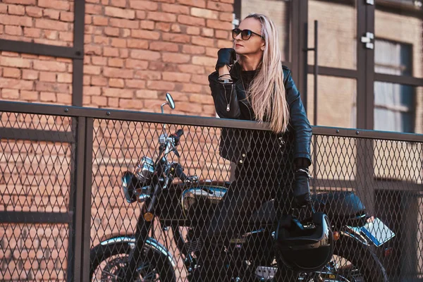 Mujer guapo motorista está posando para el fotógrafo con su moto —  Fotos de Stock