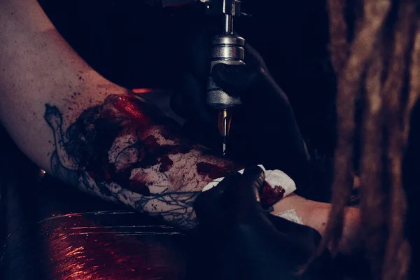Closeup photoshoot of tattoo making at dark photo studio — Stock Photo, Image
