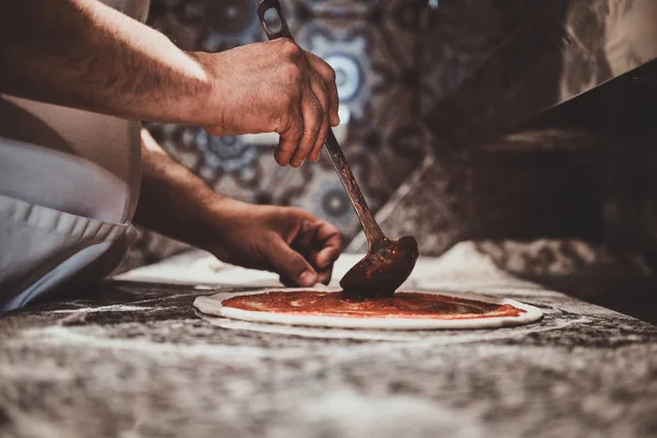 Šéfkuchař si dělá pizzu v kuchyni v restauraci — Stock fotografie