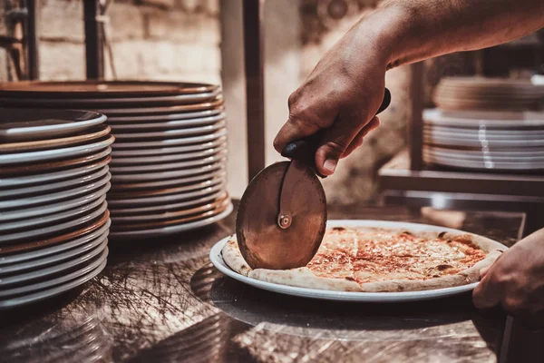 Chef-kok is snijden vers bereide pizza — Stockfoto