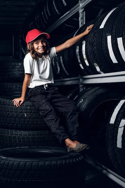 Retrato de uma menina no armazenamento de pneus escuros — Fotografia de Stock