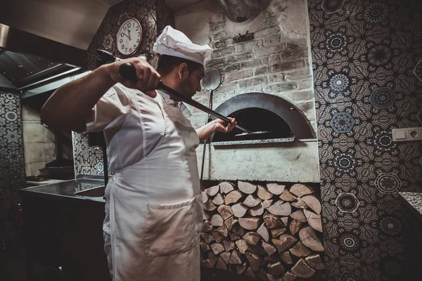 Chef-kok zet pizza in de oven — Stockfoto