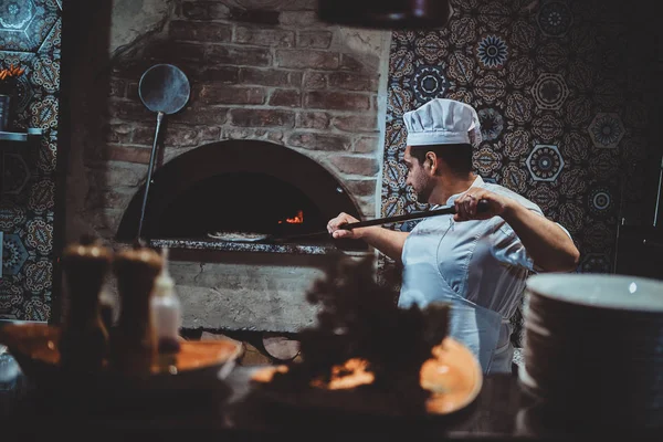 Chef met la pizza au four — Photo