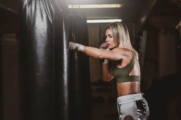 Retrato de boxeadora femenina en su entrenamiento con saco de boxeo —  Fotos de Stock