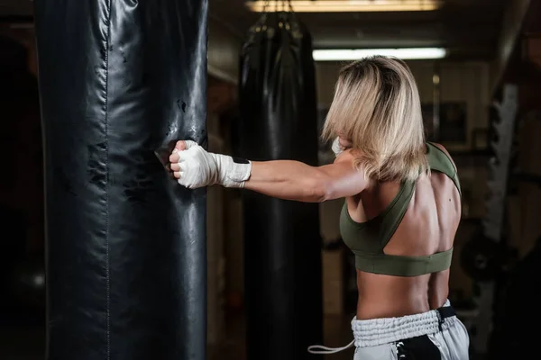 Retrato de boxeadora femenina en su entrenamiento con saco de boxeo —  Fotos de Stock