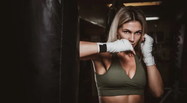 Portrait of female boxer on her training with punching bag — 스톡 사진