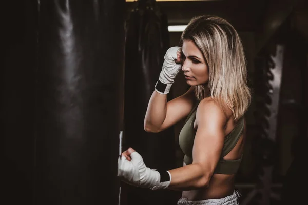 Retrato de boxeadora femenina en su entrenamiento con saco de boxeo —  Fotos de Stock