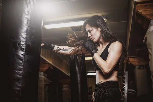 女性ボクサーの肖像画で彼女のトレーニングとともにパンチングバッグ — ストック写真