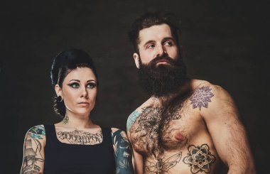 Fotoğraf stüdyosundaki dövmeli kadın ve erkeğin portresi.