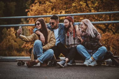 Gözlüklü kız arkadaşlarıyla selfie çekiyor.