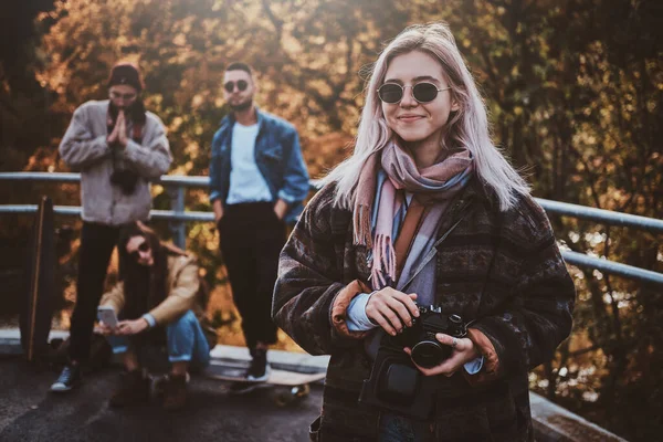 Güzel sarışın kız ve arkadaşları sonbahar parkında — Stok fotoğraf