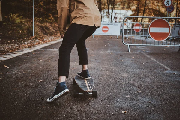 Cool student is genieten van de rit met zijn longboard — Stockfoto