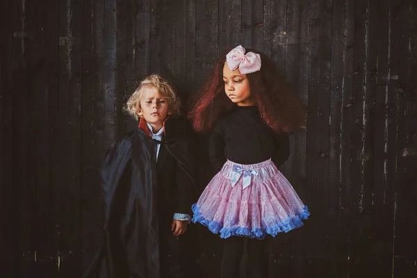 Dwoje zamyślonych dzieciaków ma na sobie kostiumy halloween — Zdjęcie stockowe