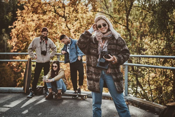 Mooi blond meisje en haar vrienden in de herfst park — Stockfoto