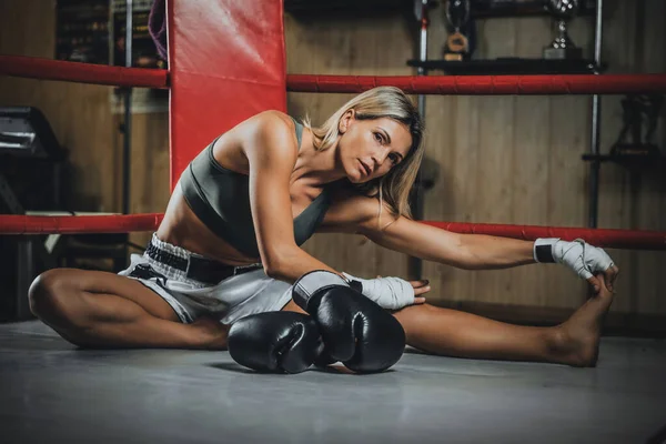 Mujer rubia boxeadora está haciendo estiramiento —  Fotos de Stock