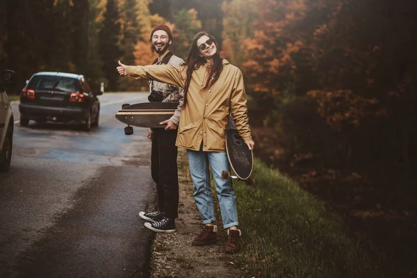 Bonita pareja están haciendo autostop en el camino — Foto de Stock