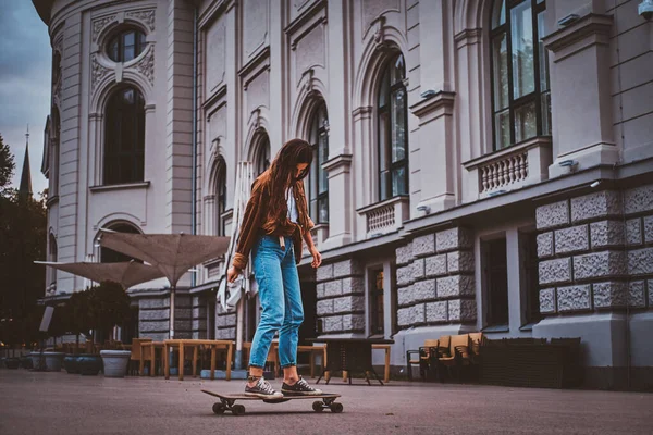 Womam is riding longboard on the street — Stock Photo, Image