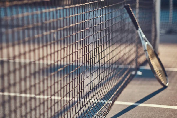 Tennisracket står nær tennisnettet. – stockfoto