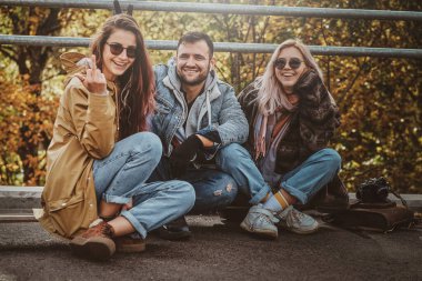 Bir grup insan parkta güneşli bir sonbahar gününün tadını çıkarıyor.