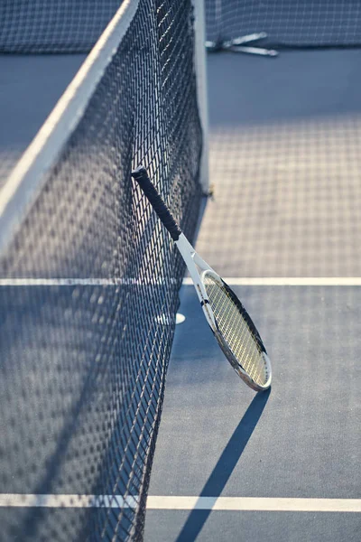 Raqueta de tenis está de pie cerca de la red de tenis — Foto de Stock