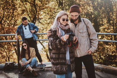 İnsanlar fotoğraf makinesinden fotoğrafları izliyorlar.