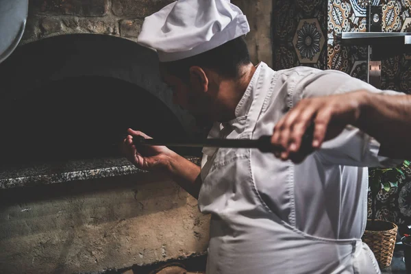 Chef-kok is het verwijderen van pizza uit de oven — Stockfoto
