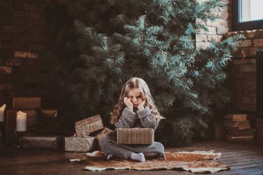 Noel ağacının yanındaki küçük şirin kızın portresi.