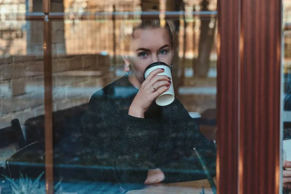 Mujer bonita está bebiendo bebidas en la cafetería — Foto de Stock