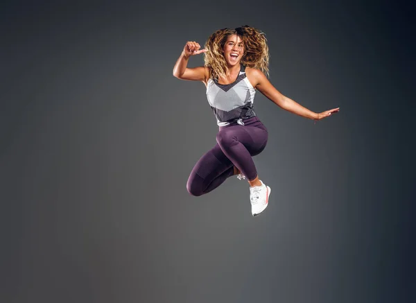 Retrato de atleta feliz pulando no estúdio — Fotografia de Stock