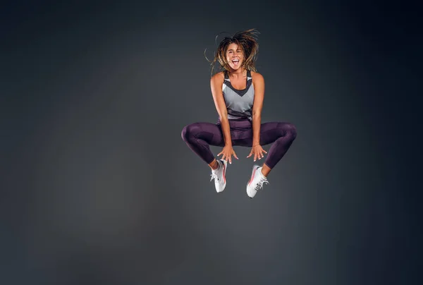 Portrait of happy athlete jumping at studio — Stock Photo, Image