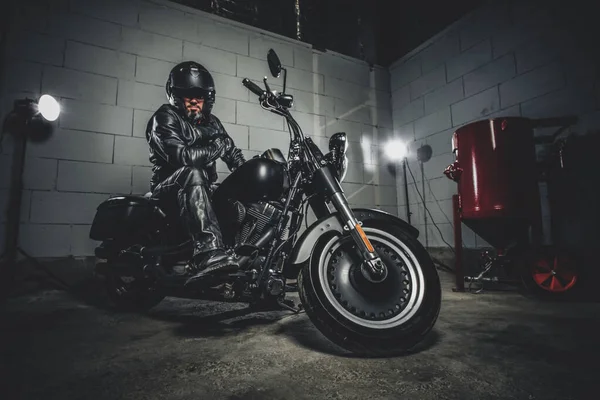 Motocyklista z motocyklem w garażu — Zdjęcie stockowe