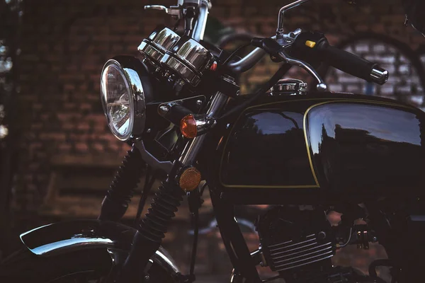 骑黑色摩托车的女骑手，她的摩托车紧靠着灰泥墙 — 图库照片